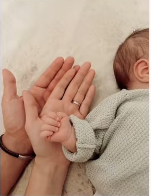Newborn hand and parent hands