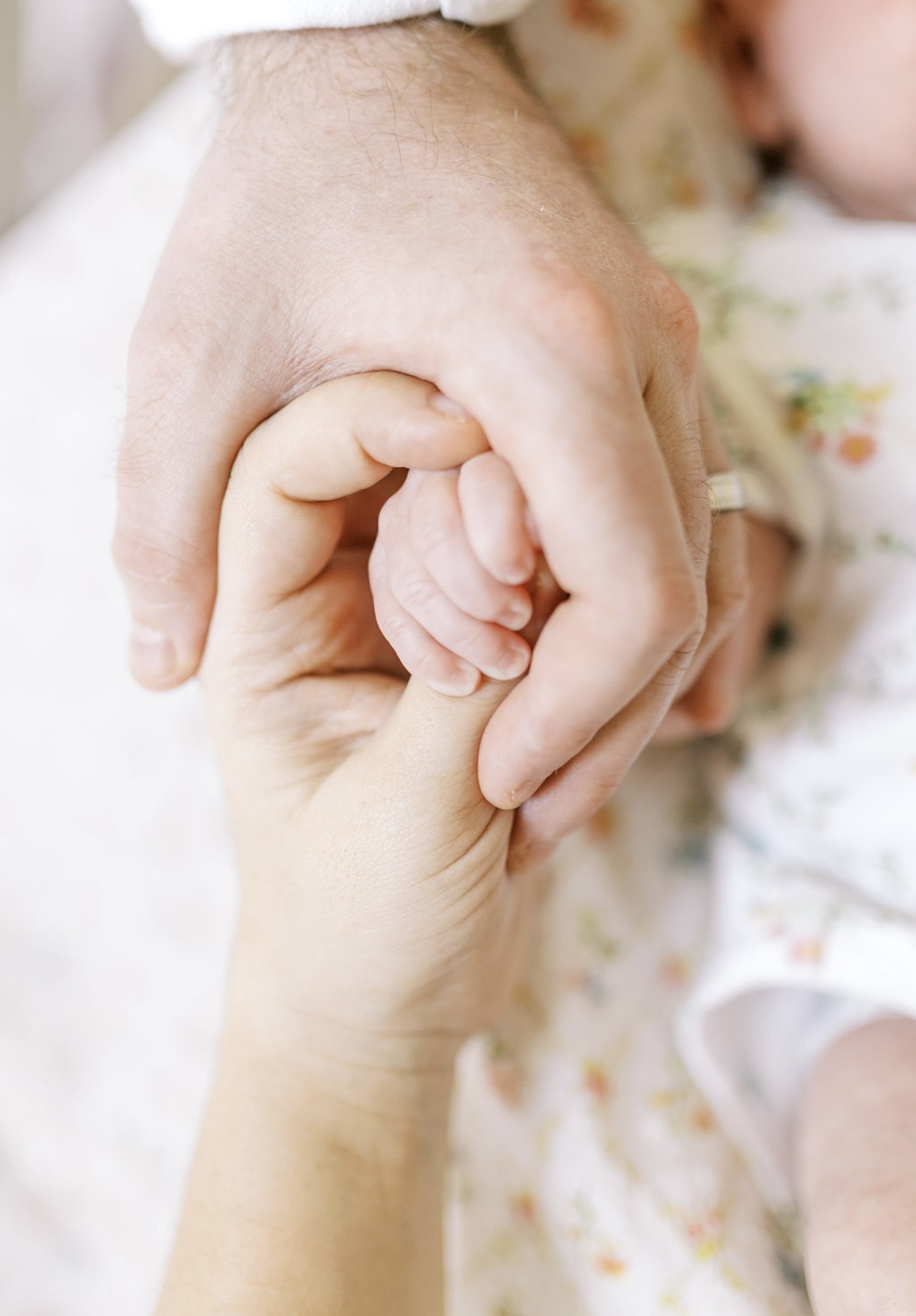Newborn hand held by a parent